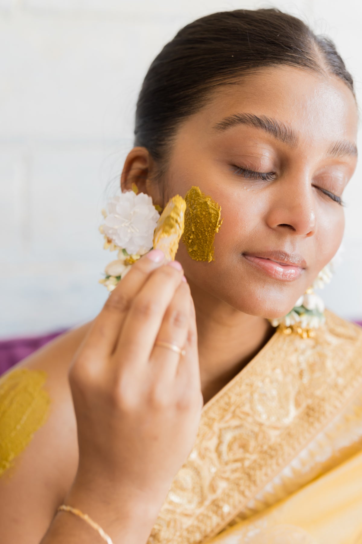 Model showcasing her skin after using glow getter on her face. Refresh dull, dehydrated skin with this glow-inducing facial powered by skin transformative plant extracts. This unique powder formula delivers deep hydration - feeding your skin with powerful antioxidants, minerals, and phytonutrients for enhanced radiance. Instantly comfort delicate complexions and revitalize fatigued skin.